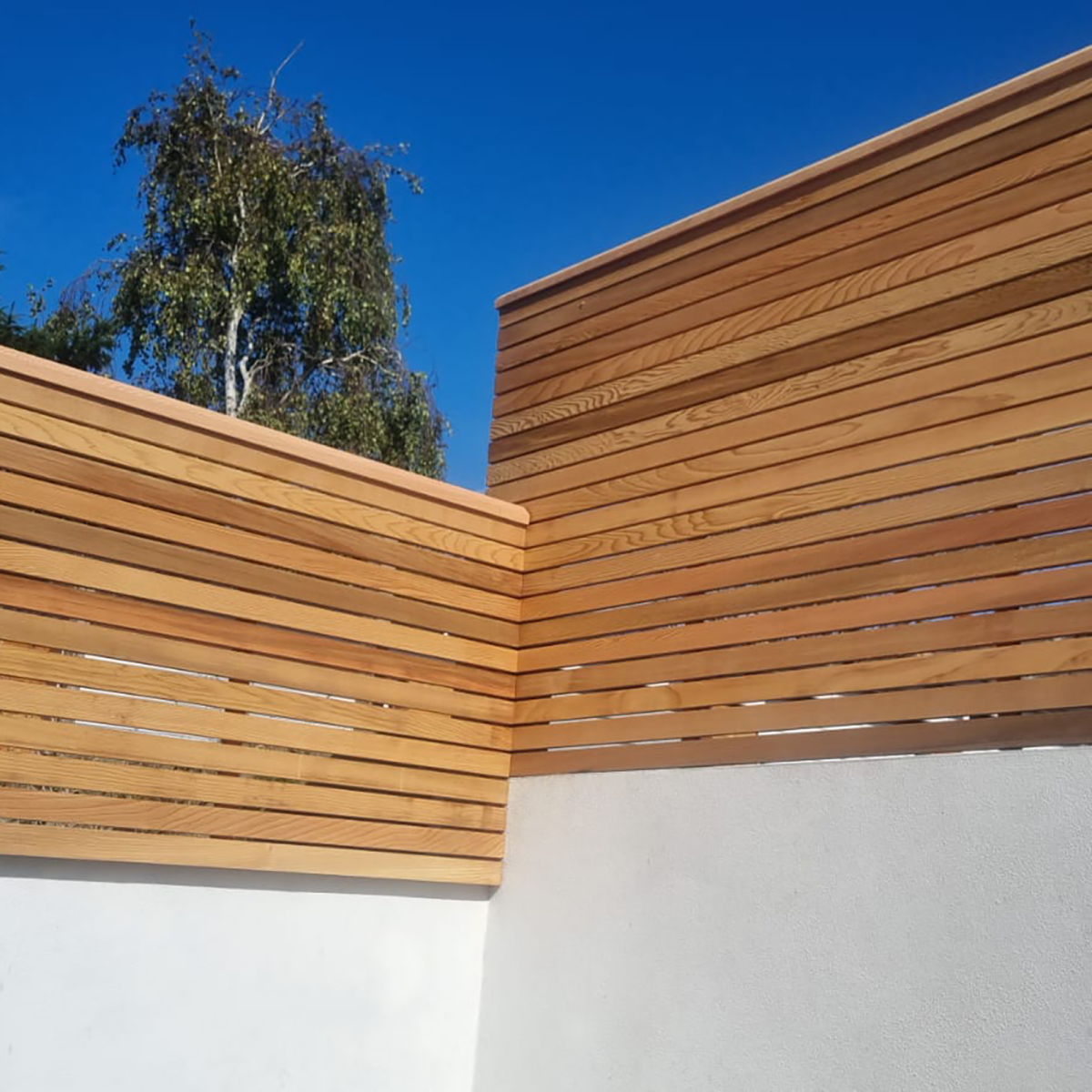 Two double sided fence panels sitting next to each other at different heights.