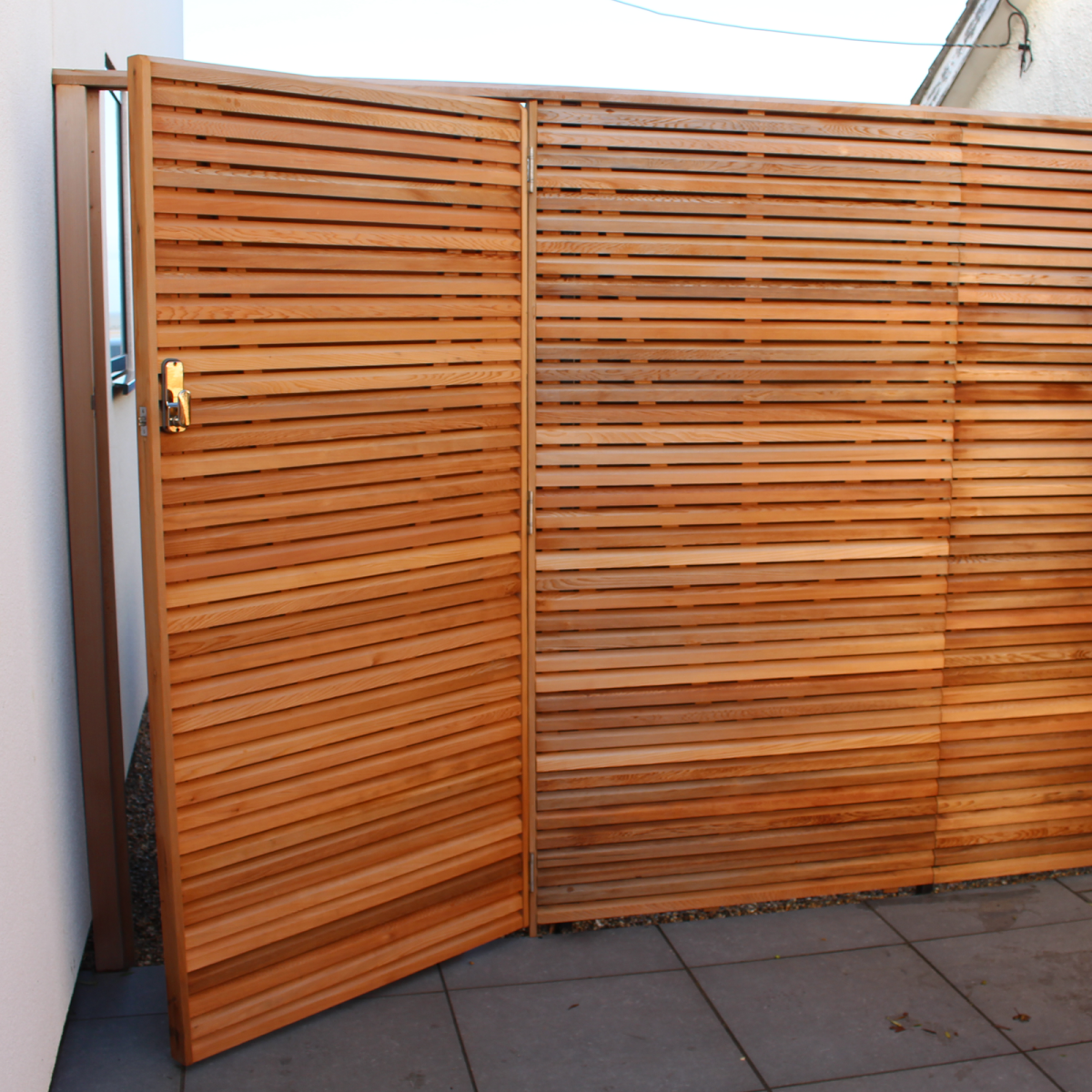An unlocked Canadian Red Cedar gate matches with the Cedar fence.