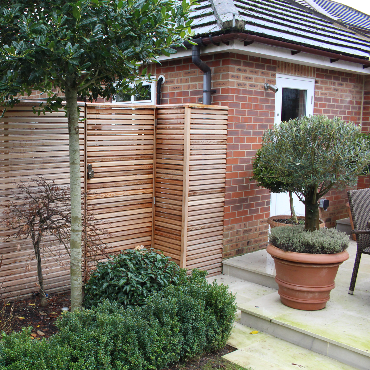 A backdoor gate to a personal garden. This gate matches with the fence (Red Cedar Slatted fencing) and is double sided.