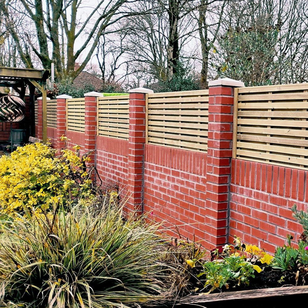 horizontal hit and miss fence panels fitted on top of a wall between brick piers