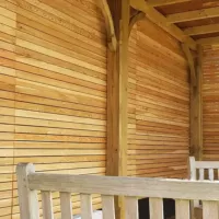 Larch panels in a pergola creates a private area to sit.