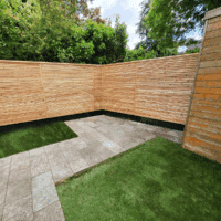 A larch fence around a corner showing the slats folling gracefully around.